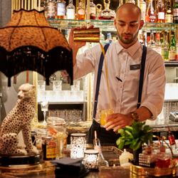 Bartender serving drinks behind a bar