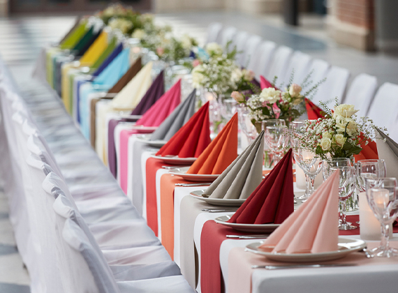 Full banquet setting with a variety of different coloured napkins and tableware