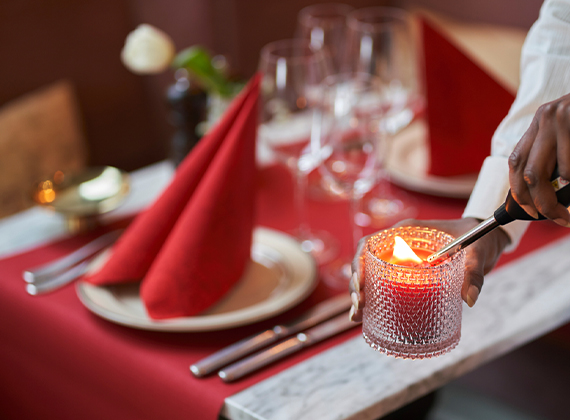 Red folded Christmas napkin on a restaurant table with candlelight