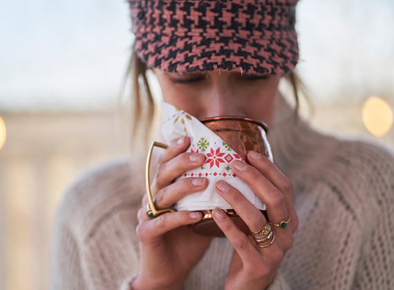 Woman holding a warm mug of hot chocolate with napkin