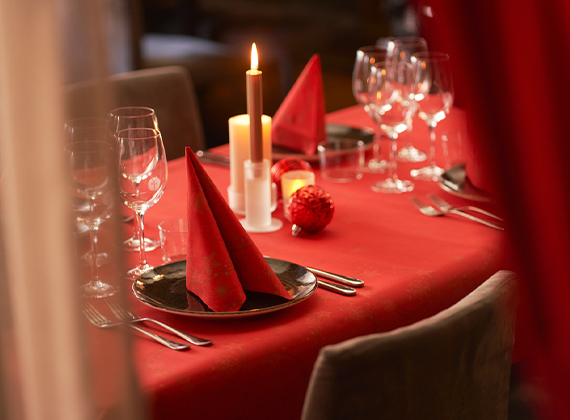Folded Star Shine Red Christmas napkin on a banquet table